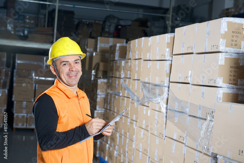 Funny worker in yellow helmet in warehouse