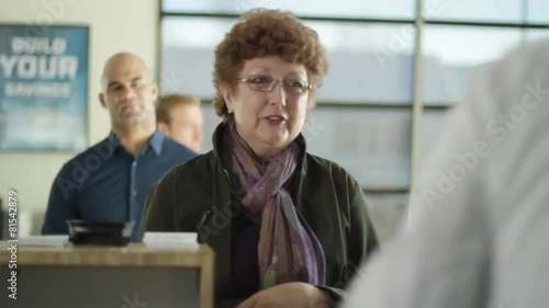 Female customer gets cash from bank teller.  