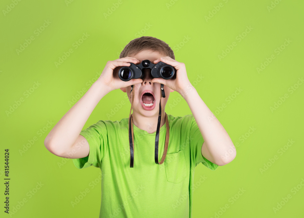 Surprised young boy with binoculars on green background. Surprised young boy with binoculars on green background.