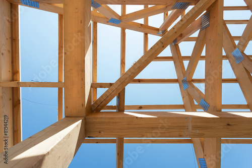 Wooden construction home framing against a blue sky