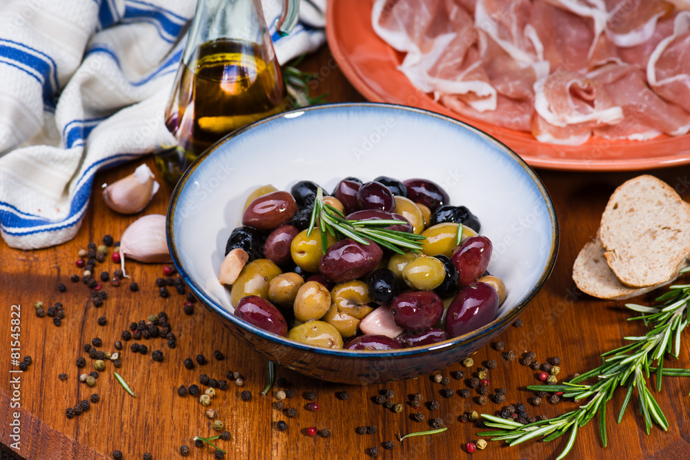 Olives in bow with prosciutto on wooden table Olives in bow with prosciutto on wooden table