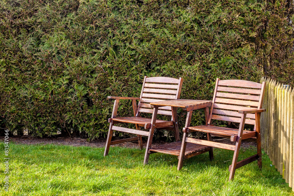wooden table and chairs on a green lawn in the backyard