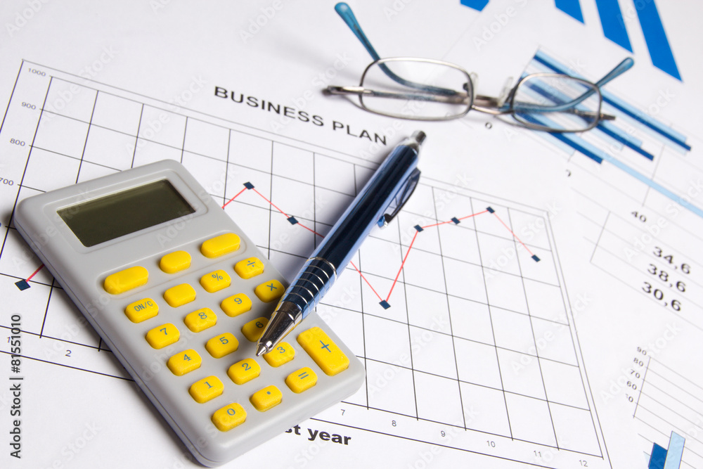 business plan concept - graphs, charts, pen, glasses and calcula business plan concept - graphs, charts, pen, glasses and calcula