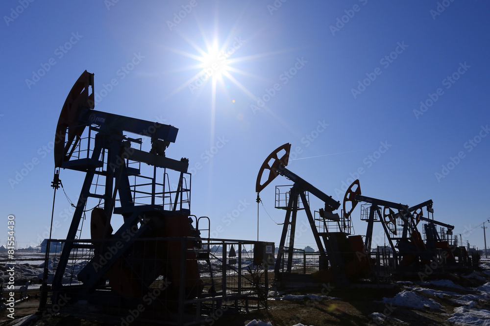 Naklejka premium oil pumps in a field in spring