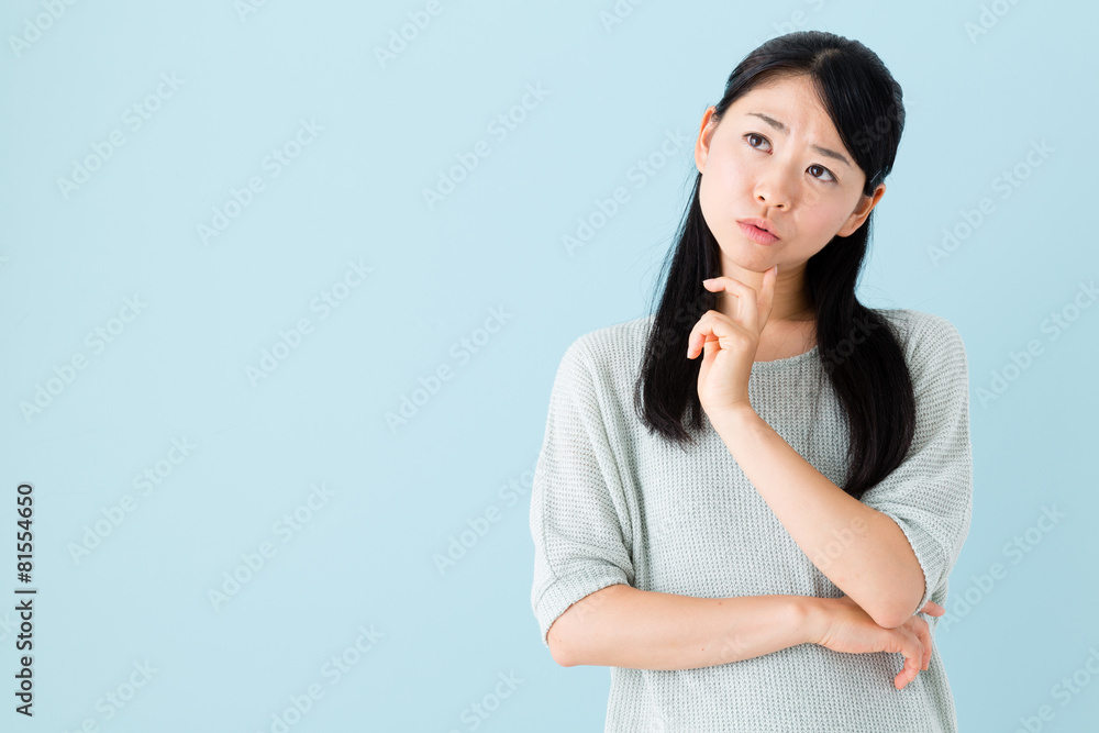 young asian woman thinking on blue background young asian woman thinking on blue background