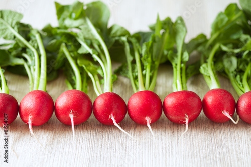 Clean eating radishes on white wooden background