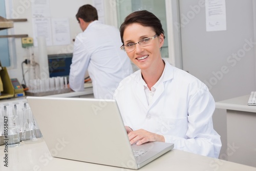 Smiling scientist using laptop