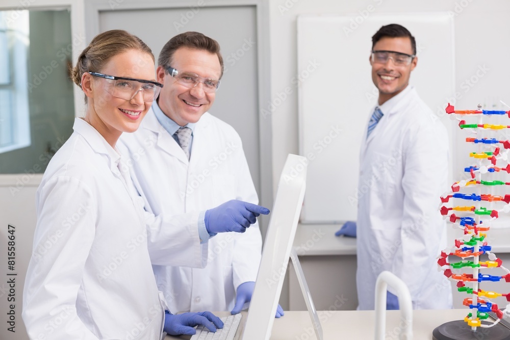Smiling scientist working with computer Smiling scientist working with computer