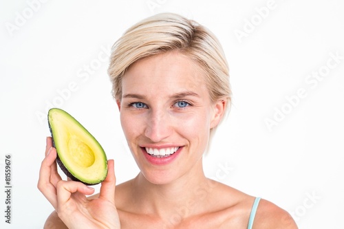 Pretty blonde holding half of an avocado