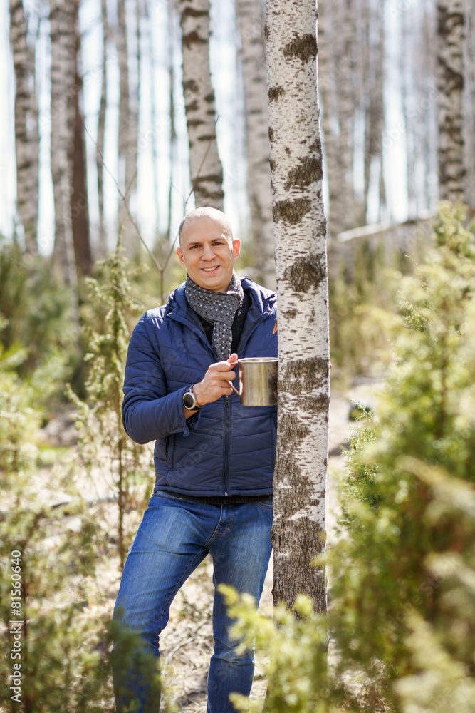 Man in woods collecting birch sap to capacity Man in woods collecting birch sap to capacity