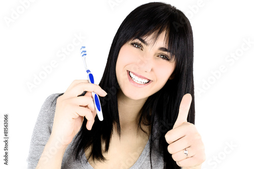 Happy girl holding tooth brush thumb up isolated