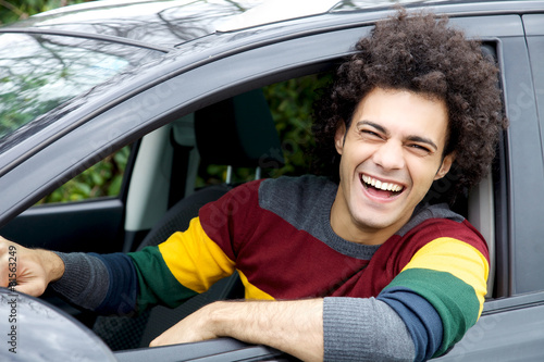 Smiling handsome italian man sitting in car looking camera
