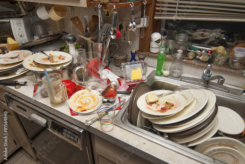 Dirty dishes over flowing in a kitchen sink