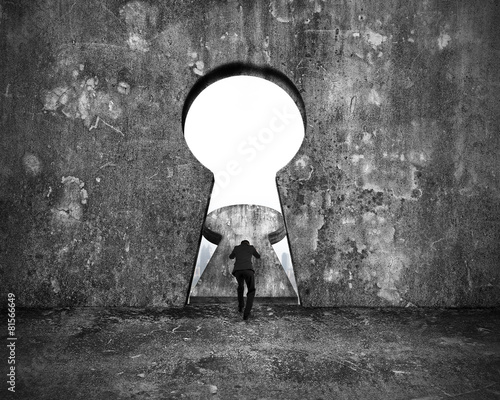 Obraz na plátne Businessman pushing keyhole door with city buildings view