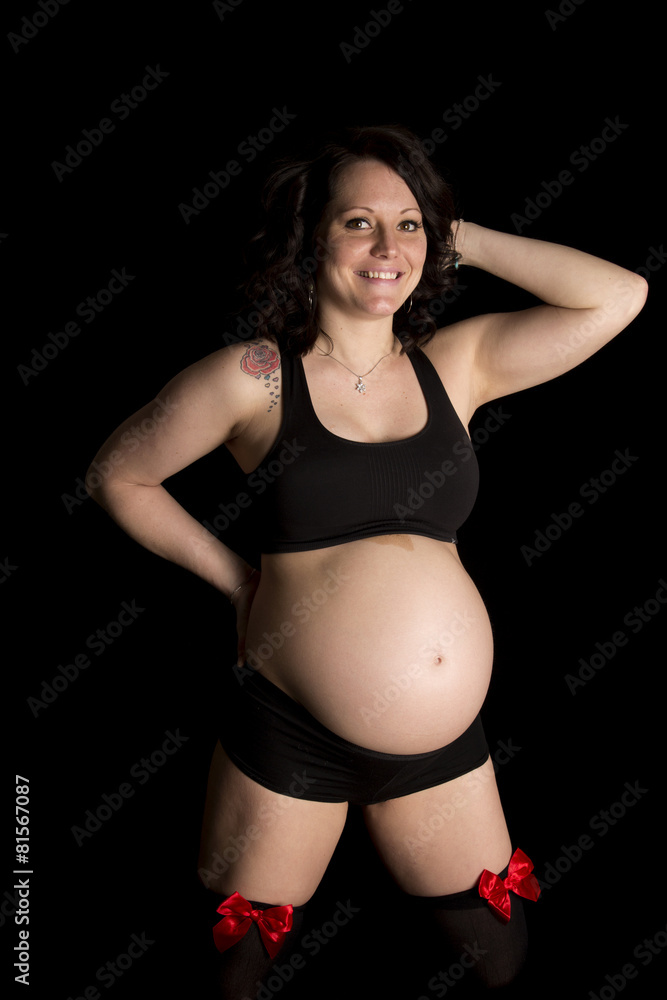 pregnant woman in black sports bra and shorts bows on legs smile Photos |  Adobe Stock