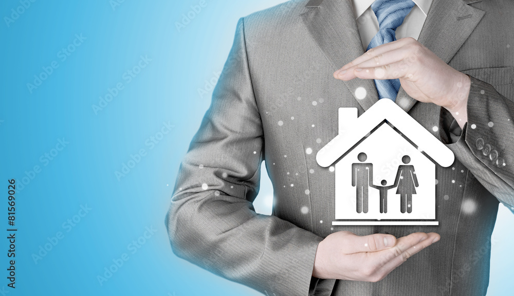 businessman protecting family in home with hands businessman protecting family in home with hands