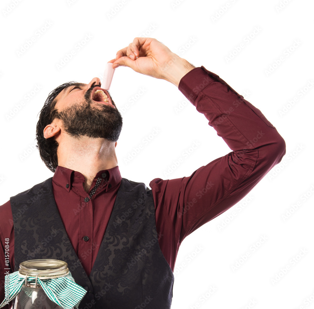 Fototapeta premium Man wearing waistcoat holding glass jar with sweets inside