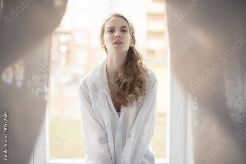 beautiful young woman in white shirt sitting on the window Free Download beautiful young woman in white shirt sitting on the window - GFXLoad