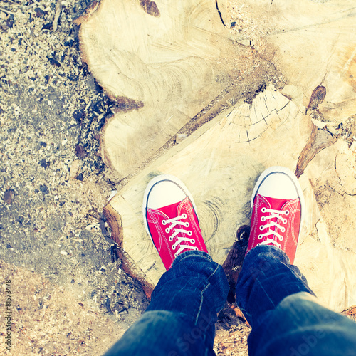 Young man feet in red sneakers on cobbled road photo