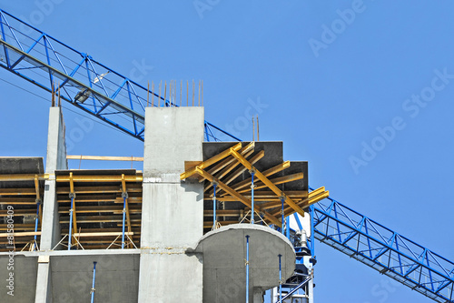 Crane and building construction site against blue sky