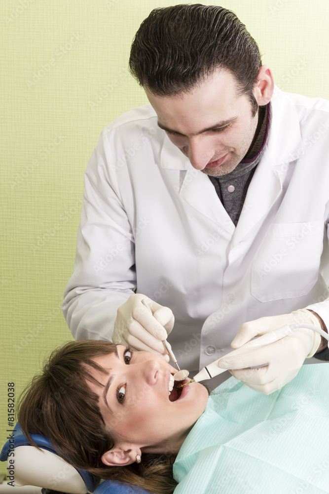 Fototapeta premium Unshaven dentist examines teeth woman smiling patients