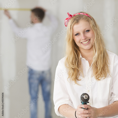 Happy young couple doing a odd-job in their new house