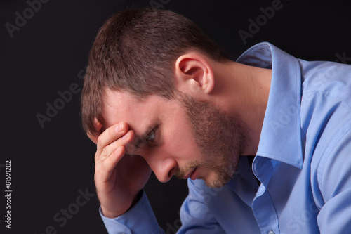 Thoughtful young man in blue shirt