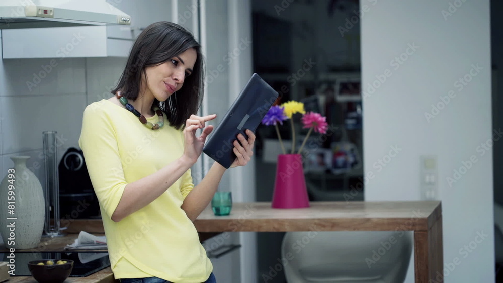 happy woman using tablet computer standing in kitchen happy woman using tablet computer standing in kitchen