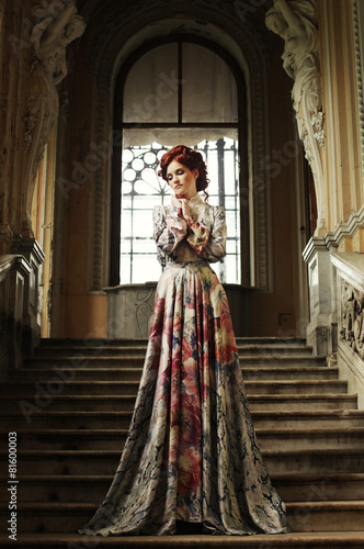 woman in elegant dress posing on stairs