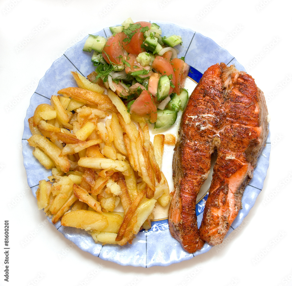 fried trout steak on a plate with potatoe and vegetable salade fried trout steak on a plate with potatoe and vegetable salade