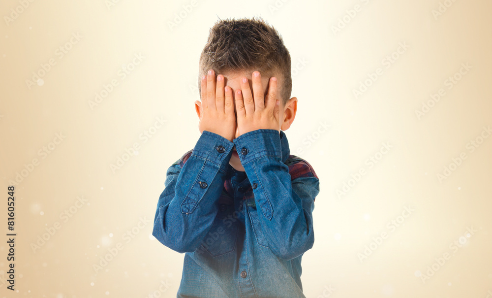 Kid covering his eyes over white background Kid covering his eyes over white background