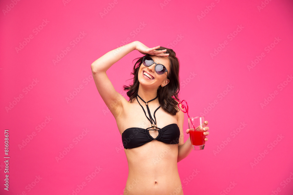 Smiling woman in swimsuit holding fresh juice Smiling woman in swimsuit holding fresh juice