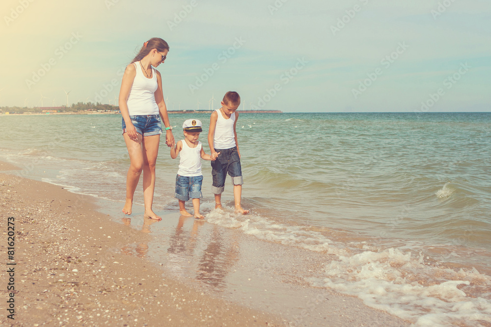 Mother and her two sons having fun on the beach Mother and her two sons having fun on the beach