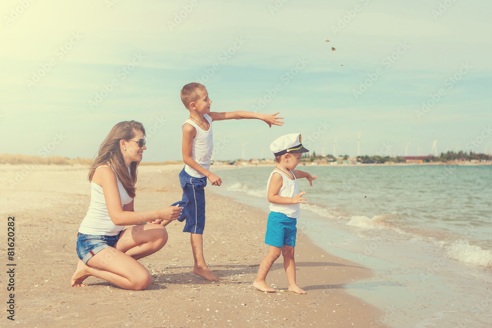 Mother and her two sons having fun on the beach