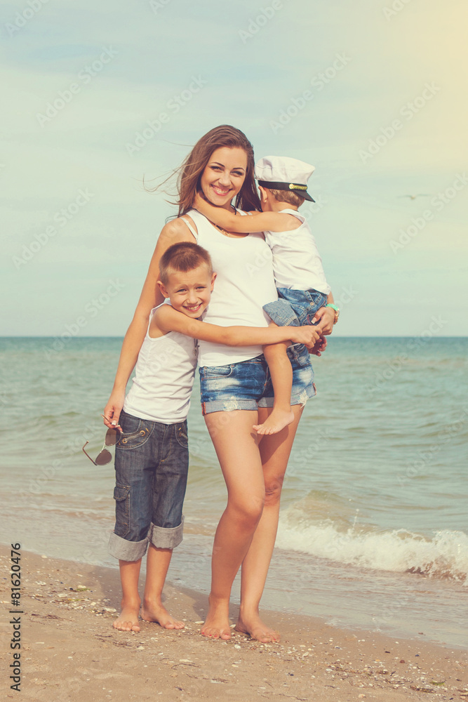 Mother and her two sons having fun on the beach Mother and her two sons having fun on the beach