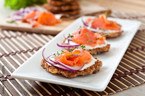 Buckwheat pancakes with salted salmon and sour cream close up