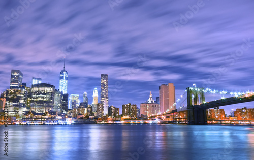 Manhattan skyline and Brooklyn Bridge at night.
