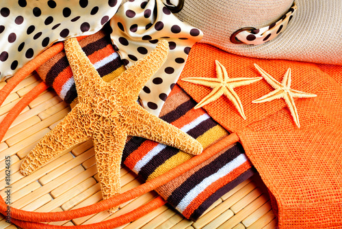 Beach bag, starfish, beach hat, towel on a wooden background