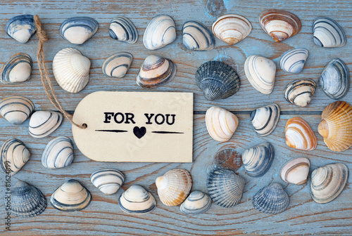 wooden background  with for you label and sea shells