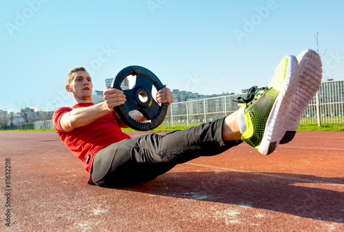 Fototapeta Naklejka Na Ścianę i Meble -  Athletic Man Lifts Weights