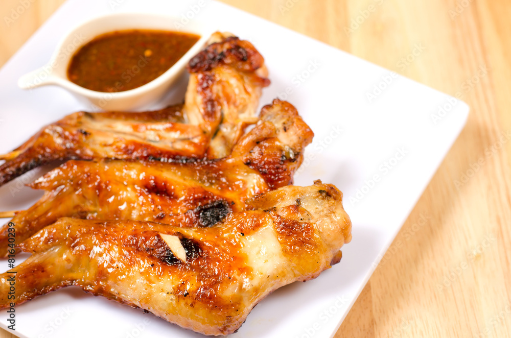 Fried chicken wings with spicy sauce on wooden table Fried chicken wings with spicy sauce on wooden table