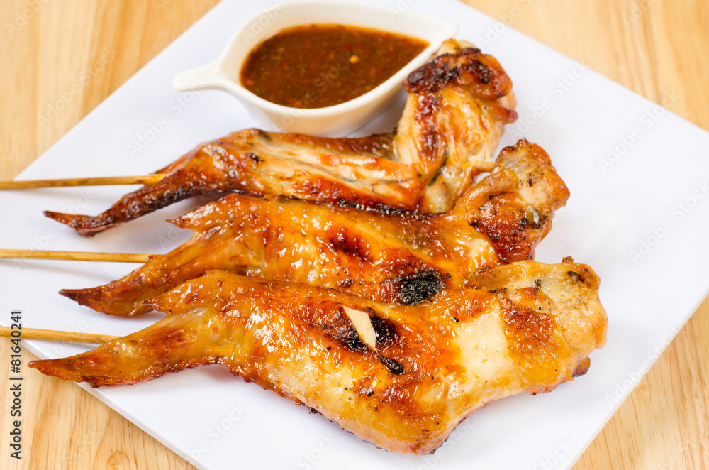 Fried chicken wings with spicy sauce on wooden table Fried chicken wings with spicy sauce on wooden table