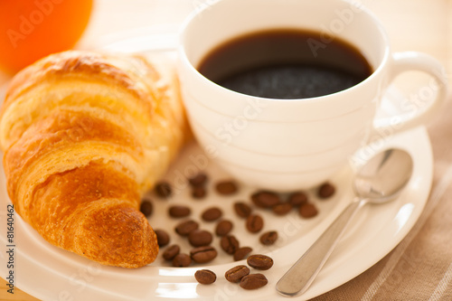 cup of coffee and croisants served for breakfast photo