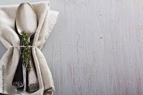 Vintage spoons and thyme on a napkin