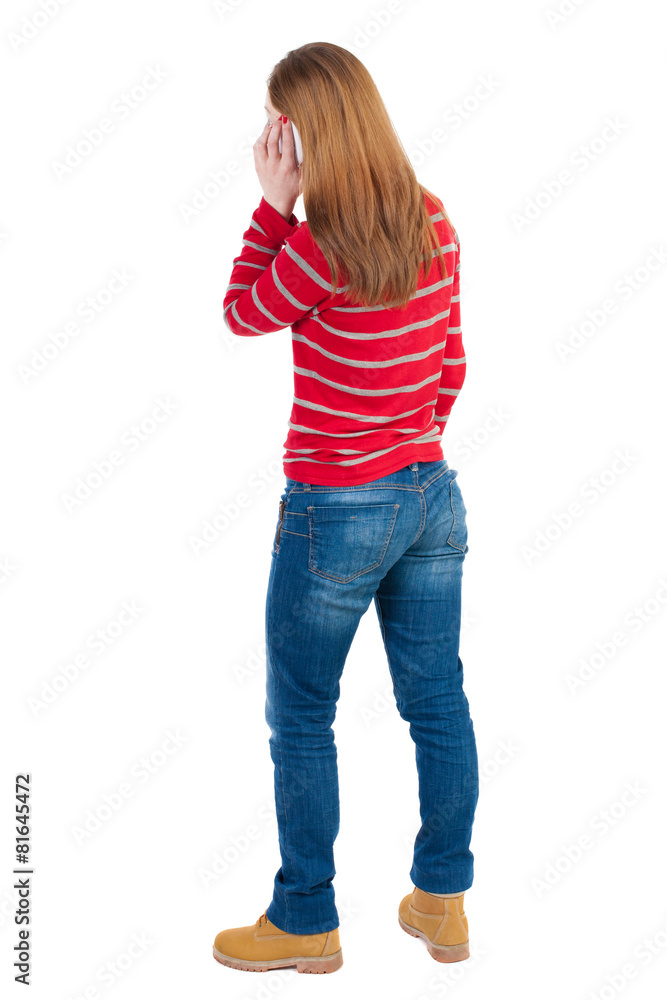 back view of standing young beautiful woman and using a mobile back view of standing young beautiful woman and using a mobile