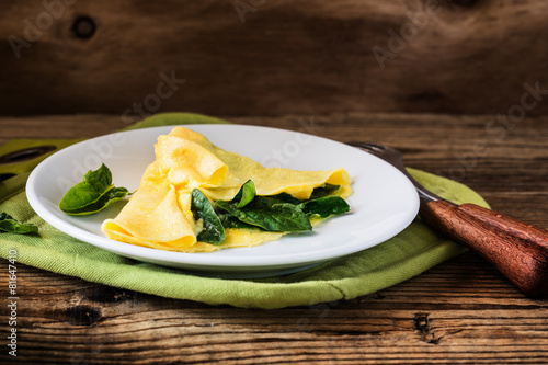 Homemade healthy spinach omelette on rural table