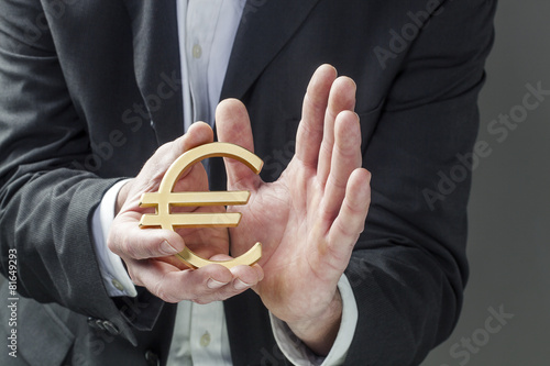 businessman caring for Euro symbol in his hands