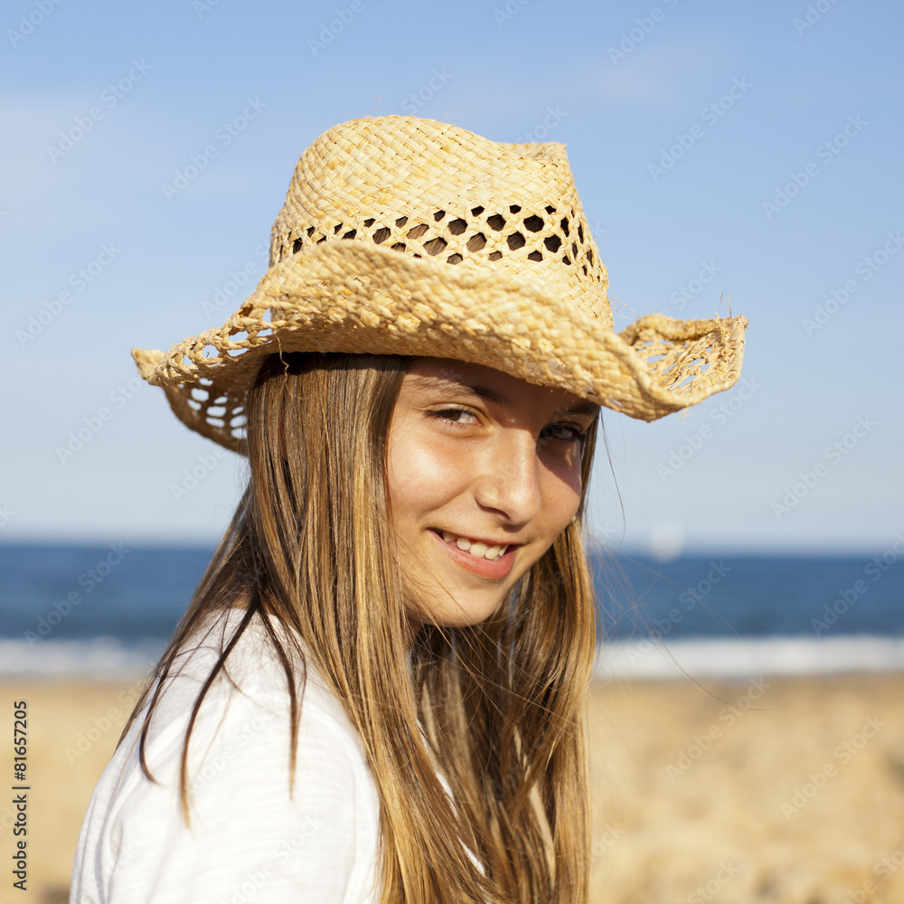 Niña con sombrero de paja en la playa