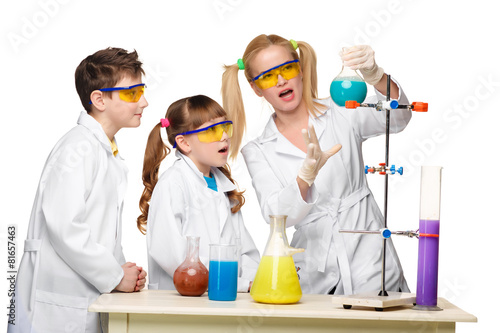 Teens and teacher of chemistry at lesson making experiments