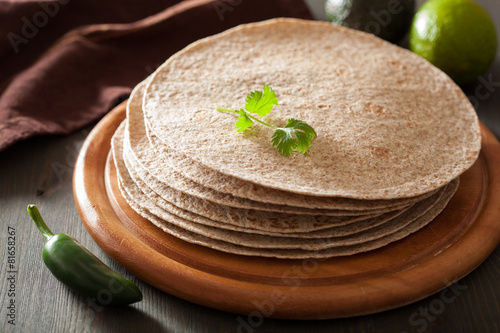 whole wheat tortillas on wooden board and vegetables